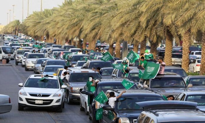 تفاعل مع سيدة تقود ناقة وسط شارع احتفالاً باليوم الوطني السعودي