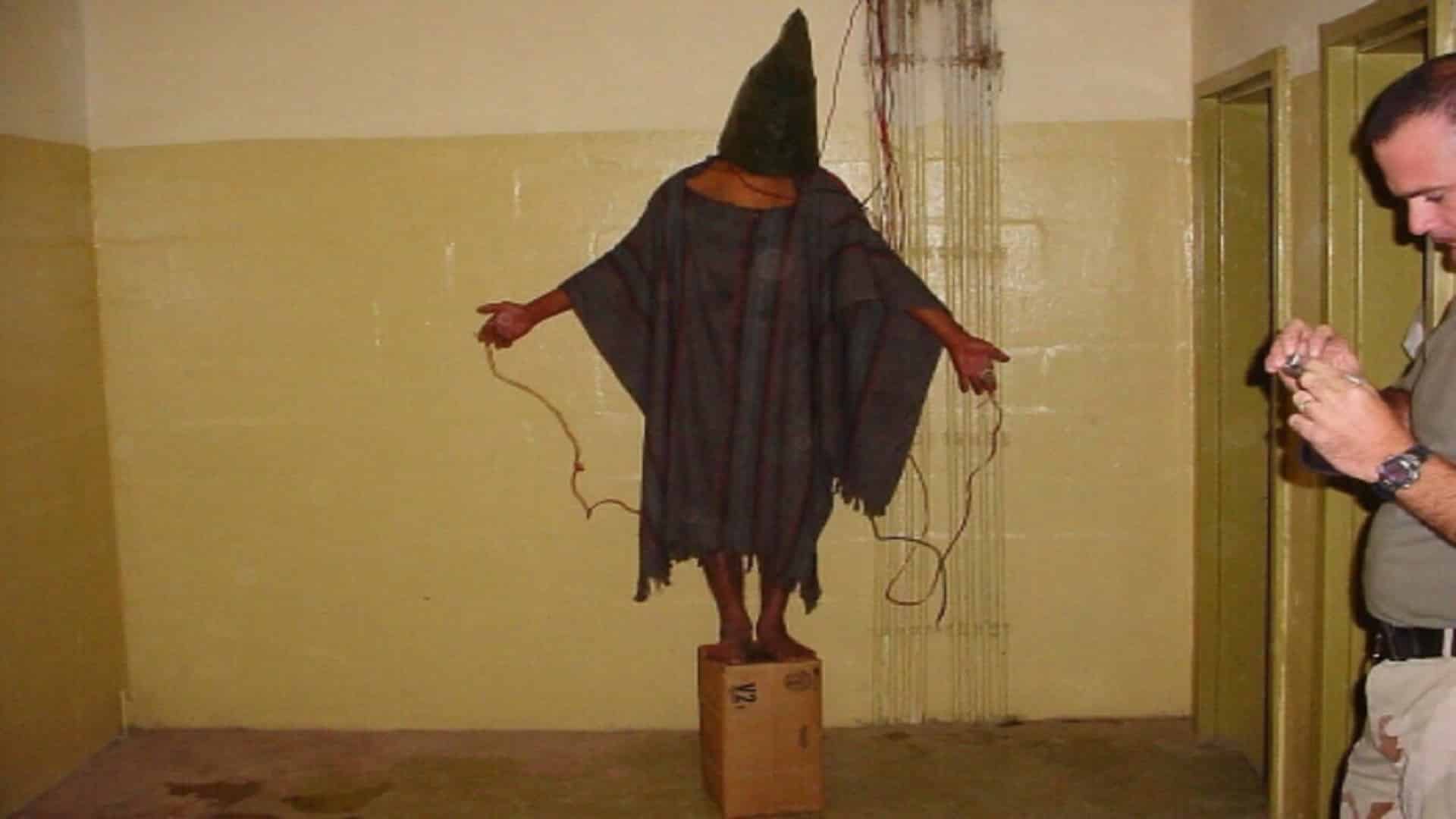 إحدى الصور التي انتشرت من سجن أبو غريب يظهر فيه تعذيب المعتقلين بصعقهم كهربائياً