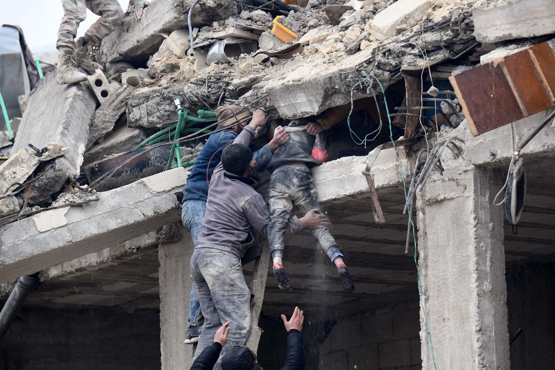 محالة إنقاذ طفل سوري من تحت الأنقاض من قبل أهالي البلدة